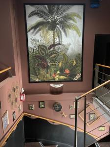 a large painting of a palm tree on a wall at Acadie Saint Victor - Hôtel restaurant - Face mer - Chatelaillon plage in Châtelaillon-Plage