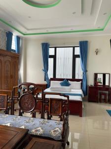 a bedroom with two beds and blue curtains at Anh Tuấn Hotel & Coffee - Pleiku, Gia Lai in Pleiku