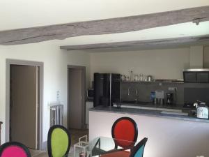 a kitchen with a counter and chairs in a room at Le Haras de Fontaine in Goulet