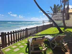2 chaises assises sur l'herbe près de la plage dans l'établissement Hakuna Matara Beach Bungalows, à Matara