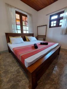 a large bed with a wooden frame in a bedroom at Mystique Hideout in Kandy