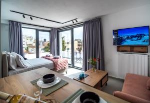 a living room with a couch and a tv at Nestia urban apartments in Volos