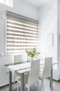 a dining room with a white table and chairs at Mediterraneo Apartment in Málaga