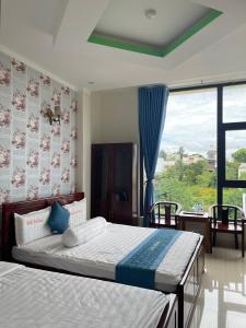 1 dormitorio con 2 camas y ventana grande en Anh Tuấn Hotel & Coffee - Pleiku, Gia Lai en Pleiku