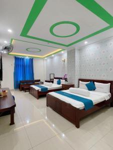 1 dormitorio con 2 camas y techo en Anh Tuấn Hotel & Coffee - Pleiku, Gia Lai en Pleiku