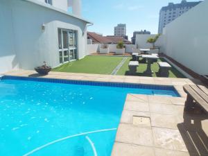 una piscina en el patio trasero de una casa en Modern Comfy 2-Bedroom Self-catering Apartment - 1 minute walk to Strand beach en Strand