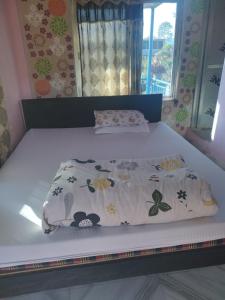 a bed with a white bedspread with animals on it at The Begnas sound healing center in Deorāli