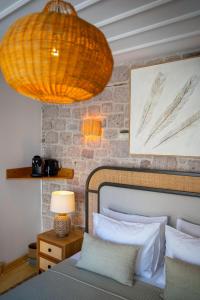 a bedroom with a bed with a lamp and a brick wall at Cundalis1893 in Ayvalık