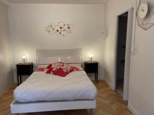 ネリ・レ・バンにあるAquanerius Résidenceのベッドルーム1室(ベッド1台、ナイトスタンド2台、時計付)