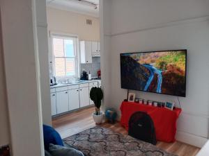 a living room with a flat screen tv on a wall at Coogee Sunrise in Sydney