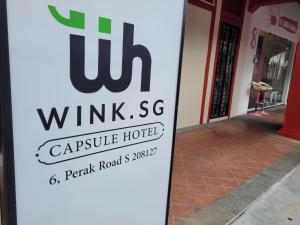 a sign for a hotel in front of a building at Wink at Perak Road in Singapore