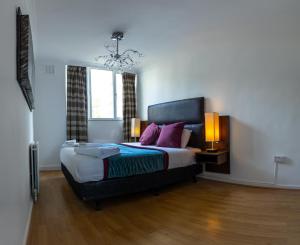 a bedroom with a large bed with purple pillows at Very Spacious and beautiful 4-Bed House in London in London