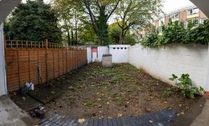 a backyard with a fence and a dirt yard at Very Spacious and beautiful 4-Bed House in London in London