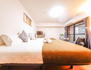 ein Schlafzimmer mit einem großen Bett und einem Fenster in der Unterkunft Lite House Shinsaibashi V in Osaka
