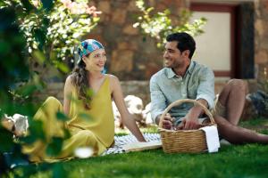 un hombre y una mujer sentados en el césped en Ikaros Beach, Luxury Resort & Spa - Adults Only, en Malia