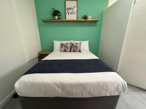 1 dormitorio con 1 cama con pared azul en Forest Gate Estate en Plettenberg Bay