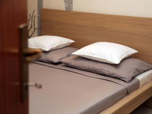 Duas almofadas em cima de uma cama em Dandelion Apartment - free parking em Fažana