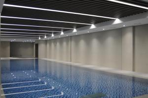 an empty swimming pool with lights on the ceiling at The Community A by City College in Goyang