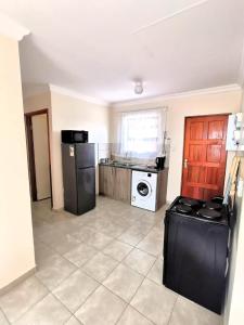 a kitchen with a refrigerator and a washing machine at MV self-catering - Rooms in Bloemfontein