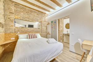 1 dormitorio con cama blanca y pared de ladrillo en Casa Bidaiari by Clabao, en Pamplona