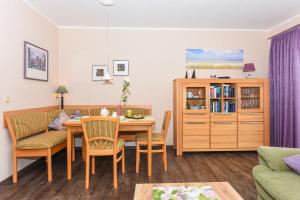 a living room with a table and chairs and a couch at Ferienhaus Sonny in Carolinensiel