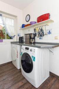 カロリーネンジールにあるFerienhaus Sonnyのキッチン(カウンター下に洗濯機付)