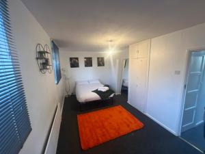 a small bedroom with a bed and a orange rug at a two bedroom cosy hideaway based in greenwich in London