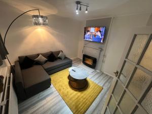 sala de estar con sofá y chimenea en a two bedroom cosy hideaway based in greenwich, en Londres