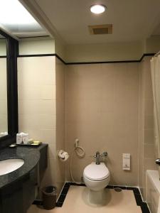 a bathroom with a toilet and a sink at โรงแรม ซี.เอส. ปัตตานี in Ban Ru Sa Mi Lae