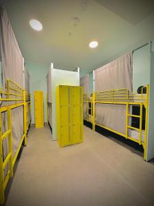 a room with two bunk beds and yellow cabinets at Breeze Lodge in Brisbane