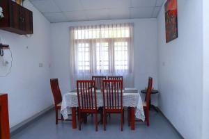 a dining room with a table and chairs and a window at Hemamala Bungalow in Anuradhapura