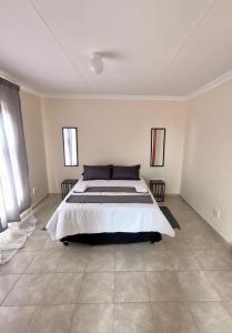 een slaapkamer met een groot bed in een kamer bij MV self-catering - Units in Bloemfontein