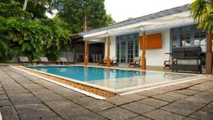 a swimming pool in front of a house at Villa Apsara by Avant Garde in Aluthgama