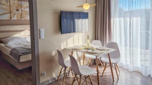 una sala da pranzo con tavolo, sedie e letto di Holiday Home Bel Mare 305e a Międzyzdroje