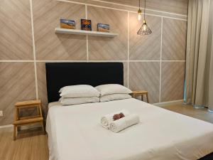 una camera da letto con un letto e due asciugamani di Modern Homestay @ Selayang Residence 280 a Kampong Jawa Tengah