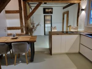 una cucina e una sala da pranzo con tavolo e sedie di Casa Linda, luxuriöse Ferienwohnung im Grünen a Ober-Ramstadt Altre 19 foto