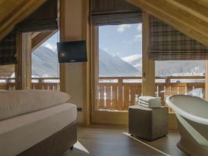 a bathroom with a tub and a view of a mountain at Hotel Amerikan in Livigno