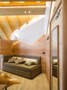 a living room with a couch in a room with wooden walls at Hotel Amerikan in Livigno