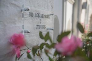 eine Steinmauer mit rosa Blumen davor in der Unterkunft Stadthaus Flensburg in Flensburg