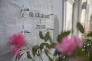 un mur en pierre avec des fleurs roses devant lui dans l'établissement Stadthaus Flensburg, à Flensbourg