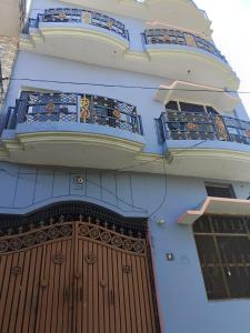 budynek z dużymi drewnianymi drzwiami i balkonem w obiekcie Shri Niwas Homestay w mieście Ayodhya