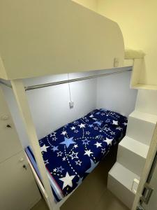 a bunk bed with a blue blanket with stars on it at Decent Holiday Homes & Hostels near Burjuman Metro Station in Dubai