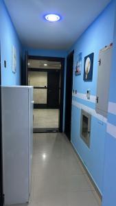 een blauwe kamer met een hal met een koelkast bij Decent Holiday Homes & Hostels near Burjuman Metro Station in Dubai