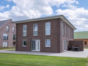 a brick building with a table on a lawn at Ferienhaus - EMILY in Burhave