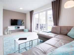 a living room with a couch and a tv at Ferienhaus - EMILY in Burhave