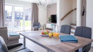 a dining room table with a bowl of fruit and juice at Ferienhaus - EMILY in Burhave