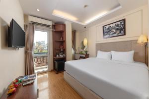Un dormitorio con una gran cama blanca y una ventana en Golden Legend Diamond Hotel, en Hanói