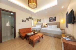 Pokój hotelowy z łóżkiem, kanapą i stołem w obiekcie Golden Legend Diamond Hotel w mieście Hanoi