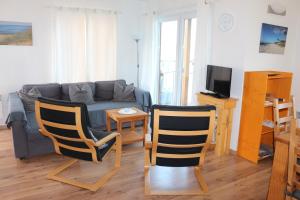 ein Wohnzimmer mit Sofa, Stühlen und einem Tisch in der Unterkunft FLOATING HOUSES - "schwimmende Ferienhäuser" - Haus 3 in Barth + 9 Fotos