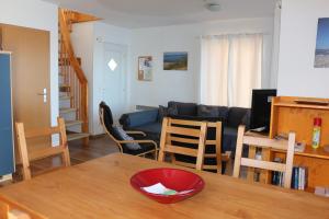 eine Küche und ein Wohnzimmer mit Tisch und Stühlen in der Unterkunft FLOATING HOUSES - "schwimmende Ferienhäuser" - Haus 3 in Barth